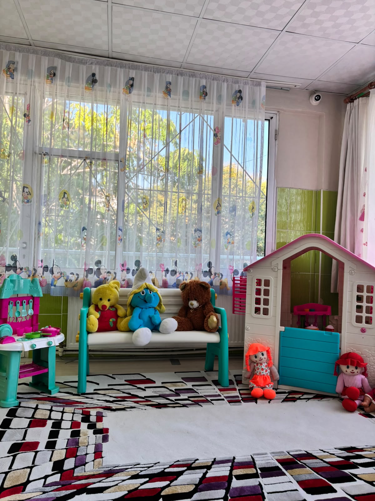 Oyuncak ev ve peluşların olduğu oyun alanı